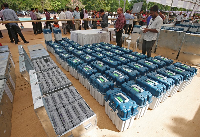 Polling officers wait to collect the election materials at a distribution centre ahead of third phase of general elections in Ahmedabad