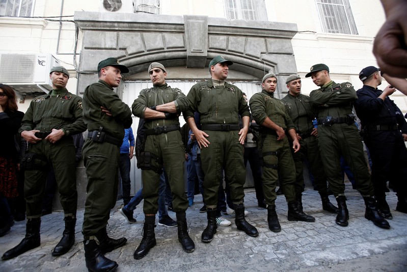 Police officers guard the gate of a court after businessmen suspected of corruption were driven into the building, in Algiers