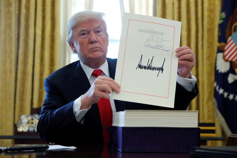FILE PHOTO: U.S. President Trump displays signbature after signing tax bill into law at the White House in Washington