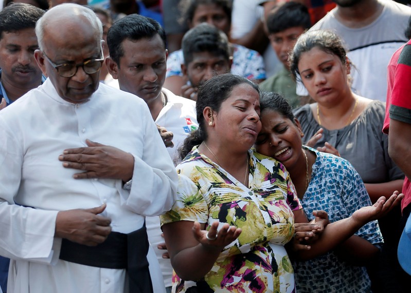 FILE PHOTO: People react during a mass burial of victims, two days after a string of suicide bomb attacks on churches and luxury hotels across the island on Easter Sunday, in Colombo