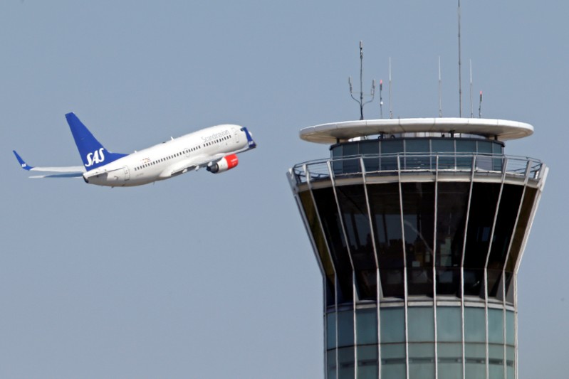 FILE PHOTO: A Scandinavian SAS airline passenger plane flies near the air traffic control tower at Roissy airport, near Paris