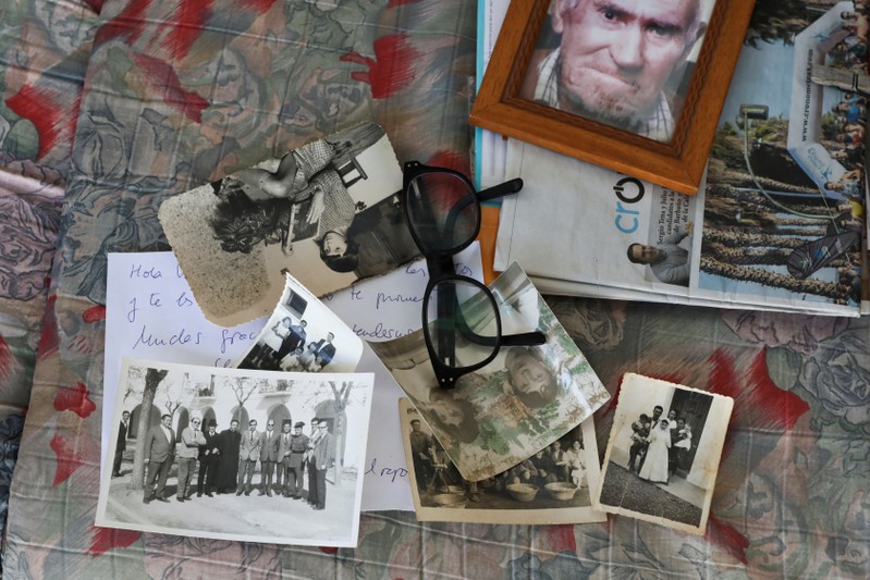 Old pictures belonging to Vicenta Prado's family lie on a couch after an interview with Reuters in Guadiana del Caudillo