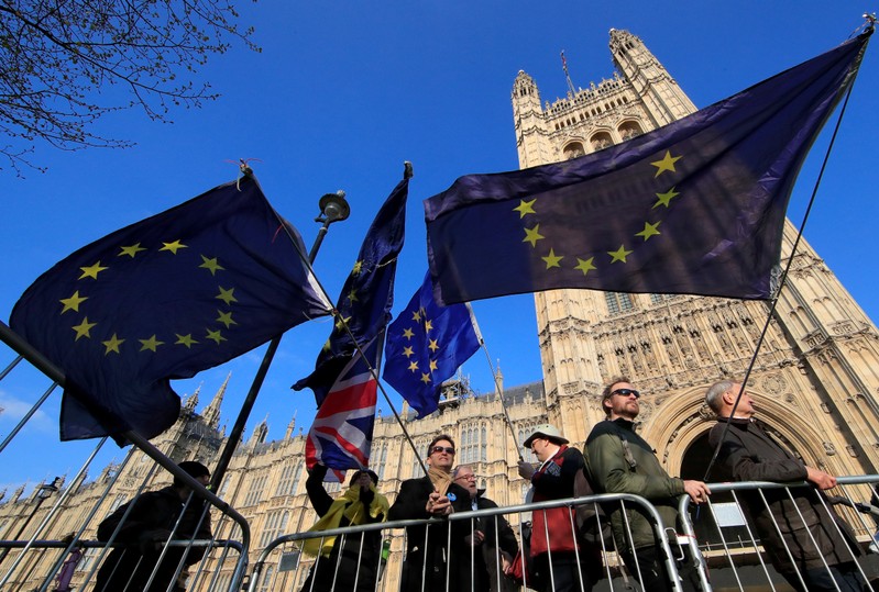 Anti-Brexit protesters hold EU flags as they demonstrate outside the Houses of Parliament in London
