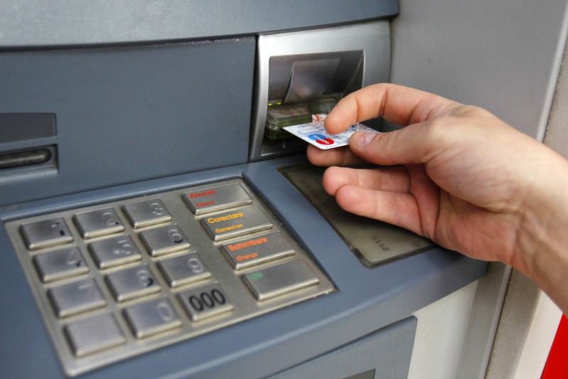FILE PHOTO - Man uses traditional ATM in Bucharest
