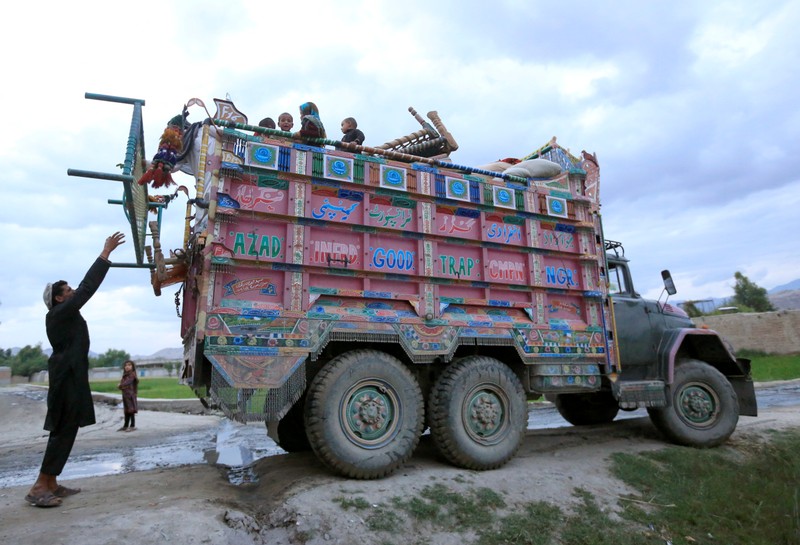 Afghan villagers who fled from the fighting sides arrive at the Behsud district of Nangarhar province
