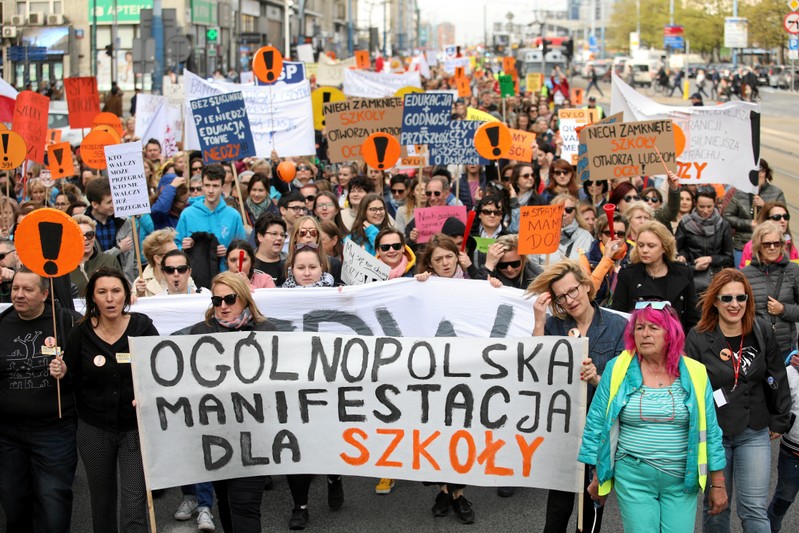 People hold banners during a rally to support a nationwide teachers' strike in central Warsaw