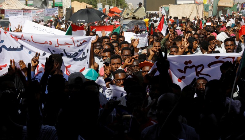 Sudanese protesters march outside the defence ministry compound in Khartoum