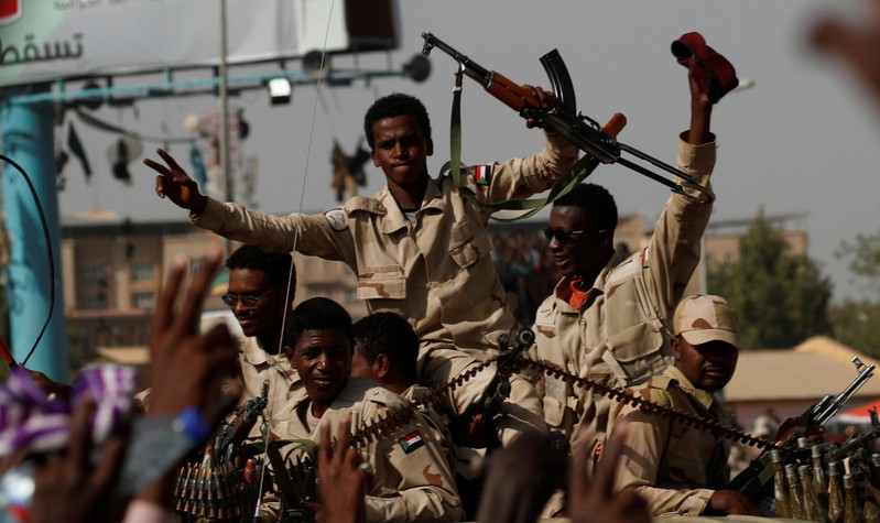 Sudanese soldiers are seen on their vehicles as they move with a military convoy outside the defense ministry compound in Khartoum