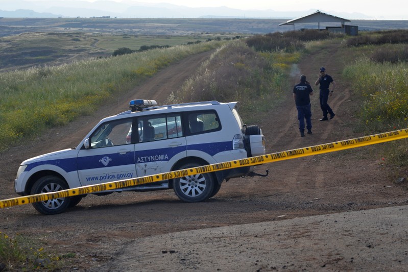 Police secure the area where the body of a woman was discovered near the village of Orounta