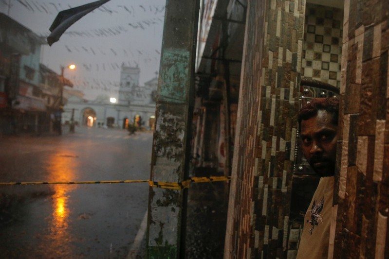 A man stands in a doorway near the security cordon surrounding St. Anthony's Shrine, days after a string of suicide bomb attacks on churches and luxury hotels across the island on Easter Sunday, in Colombo