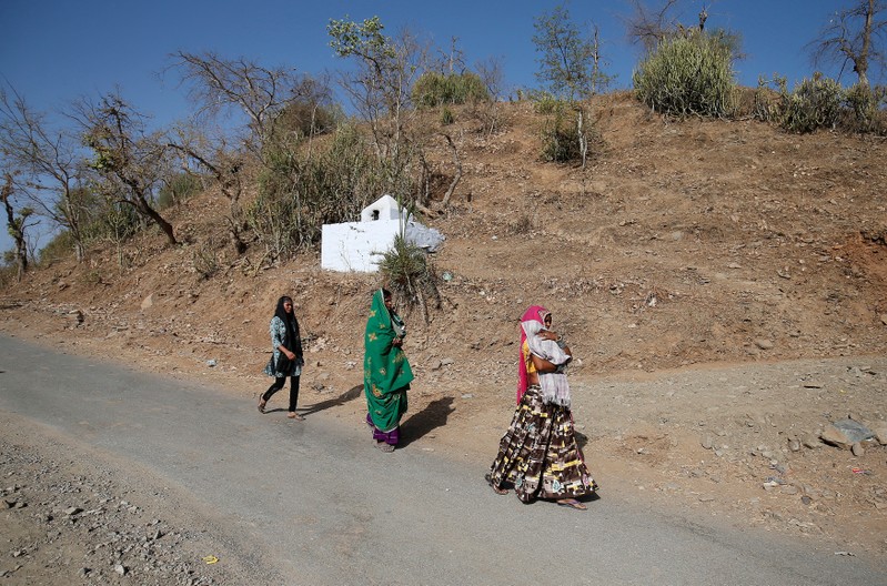 Women walk toward a polling station to cast their vote at Sirohi