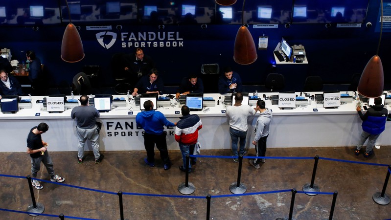 FILE PHOTO: People make their bets at the FANDUEL sportsbook during the Super Bowl LIII in East Rutherford, New Jersey