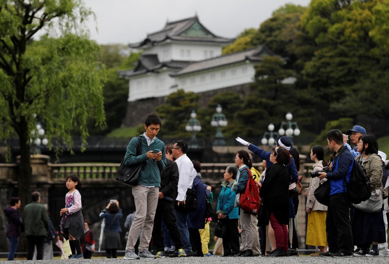 Tourists visit the Imperial Palace in Tokyo
