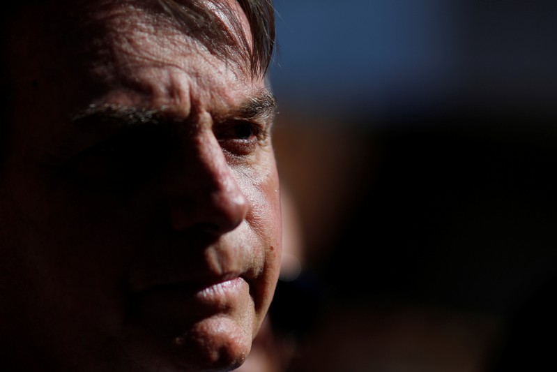 Brazil's President Jair Bolsonaro speaks with journalists after visiting Yasmin Alves at the Estrutural slum, in Brasilia