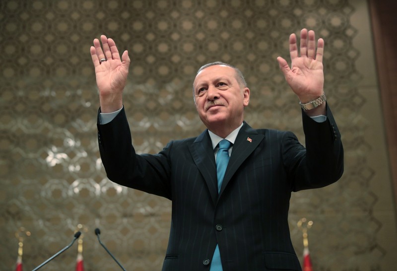 Turkish President Erdogan greets the audience during a meeting in Ankara