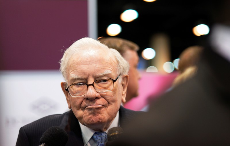 Warren Buffett, CEO of Berkshire Hathaway Inc, talks to a reporter in the exhibit hall at the company's annual meeting in Omaha