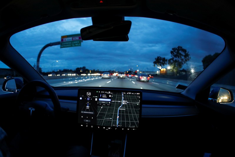 FILE PHOTO: A Model 3 Tesla vehicle navigates morning rush hour using the car's auto pilot feature in Los Angeles