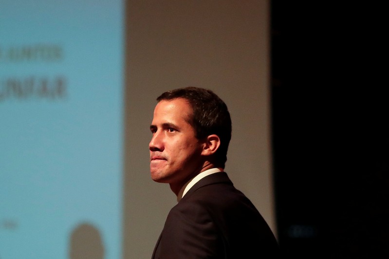 Venezuelan opposition leader Juan Guaido, who many nations have recognised as the country's rightful interim ruler, arrives on stage to deliver a speech during a meeting with workers of Venezuela's state oil company PDVSA in Caracas