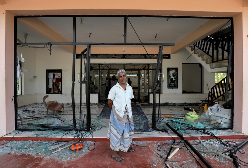 A Muslim man stands in front of the Abbraar Masjid mosque after a mob attack in Kiniyama