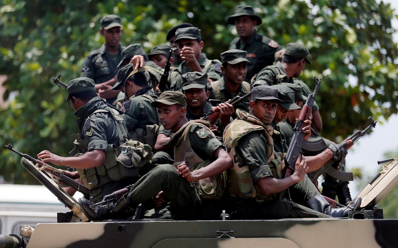 Sri Lankan soldiers patrol a road of Hettipola on top of an armored vehicle, after a mob attack in a mosque in the nearby village of Kottampitiya