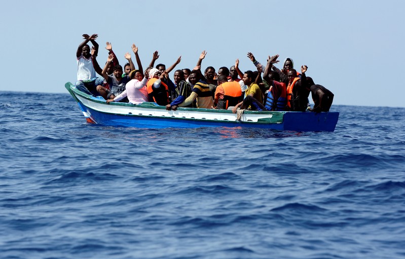 FILE PHOTO: Migrants wait to be rescued by SOS Mediterranee and Doctors Without Borders during a search and rescue operation with the MV Aquarius rescue ship in the Mediterranean