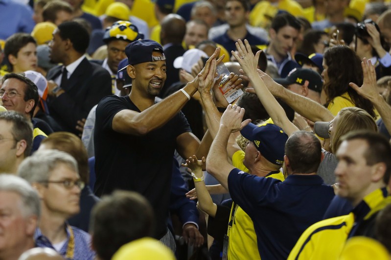 Miami Heat NBA player Juwan Howard celebrates with fans ahead of the Michigan Wolverines' NCAA men's Final Four championship basketball game against the Louisville Cardinals in Atlanta