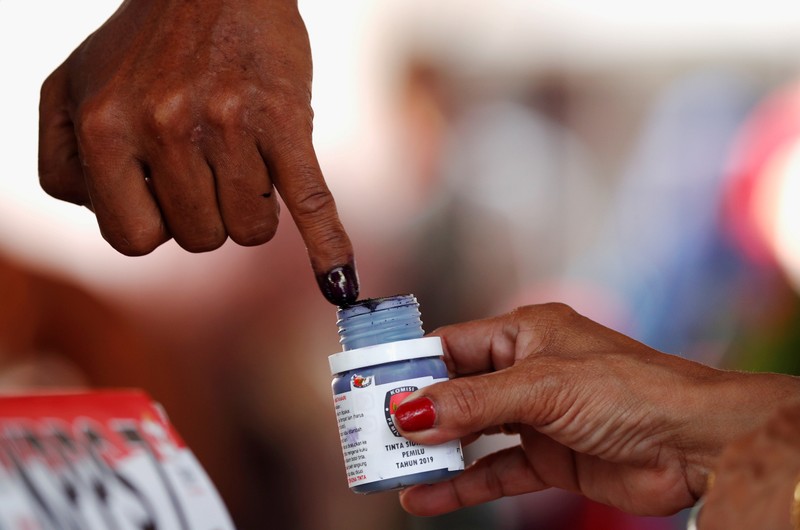 FILE PHOTO: A voter's finger is dipped with ink after voting during elections in Jakarta, Indonesia