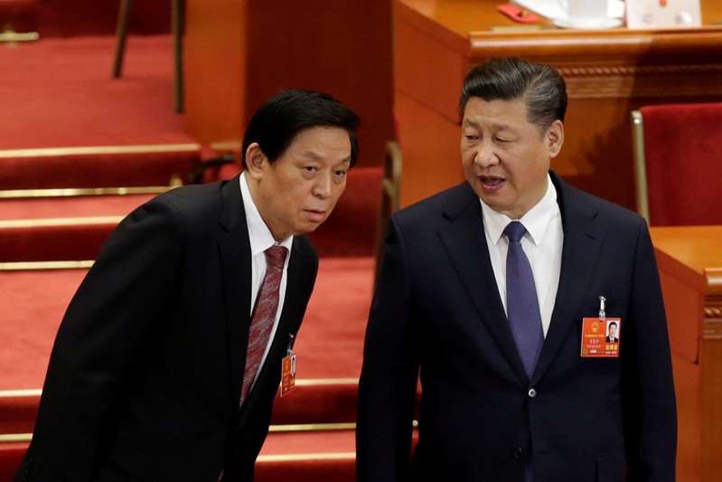 FILE PHOTO: Chinese President Xi Jinping speaks with Chinese Politburo Standing Committee member Li Zhanshu at the third plenary session of the National People's Congress (NPC) at the Great Hall of the People in Beijing