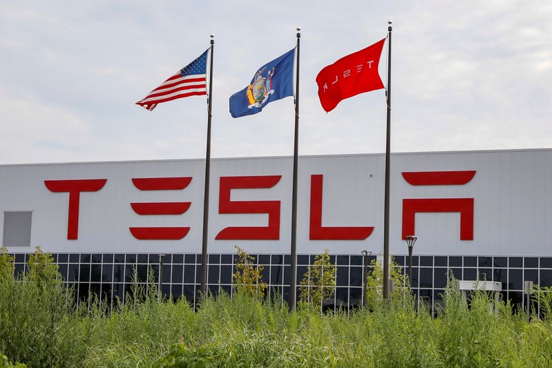 FILE PHOTO: Flags fly over the Tesla Inc. Gigafactory 2, which is also known as RiverBend, a joint venture with Panasonic to produce solar panels and roof tiles in Buffalo, New York