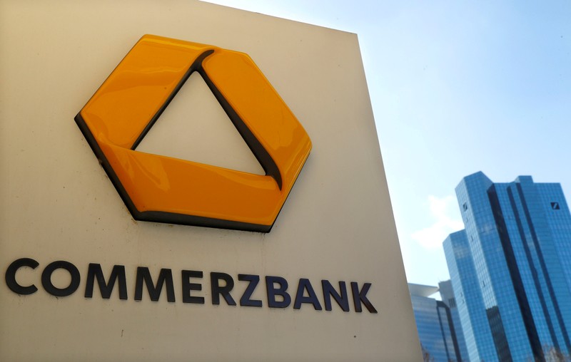 FILE PHOTO: FILE PHOTO: A sign for an ATM of Commerzbank is seen next to the headquarters of Deutsche Bank (R) in Frankfurt