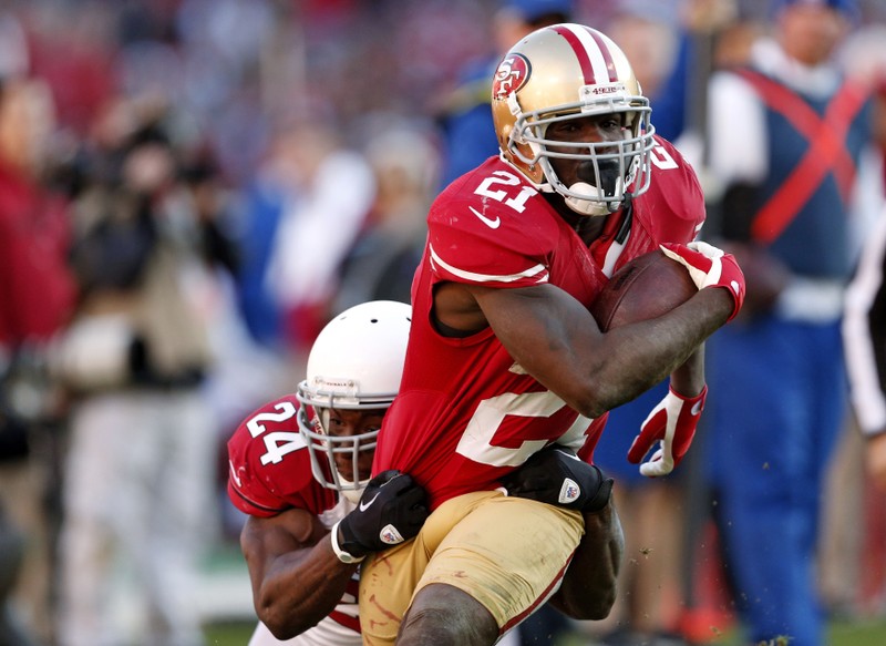 FILE PHOTO: San Francisco 49ers' Gore rushes with the ball as Arizona Cardinals' Wilson tries to tackle during their NFL football game in San Francisco