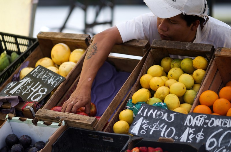 FILE PHOTO: A vegetable seller grabs an apple at a street market