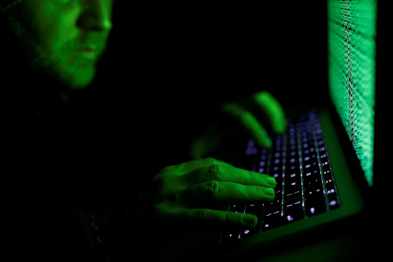 Man types on a computer keyboard in front of the displayed cyber code in this illustration picture