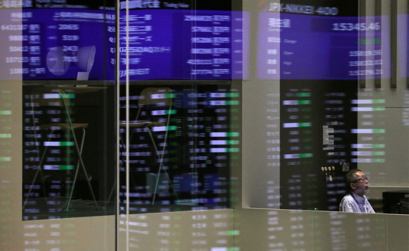 FILE PHOTO: Market prices are reflected in a glass window at the TSE in Tokyo