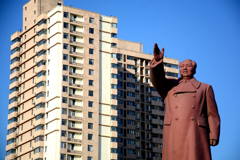 FILE PHOTO: Statue of former Chinese chairman Mao Zedong is seen in front of a residential building in Dandong New Zone