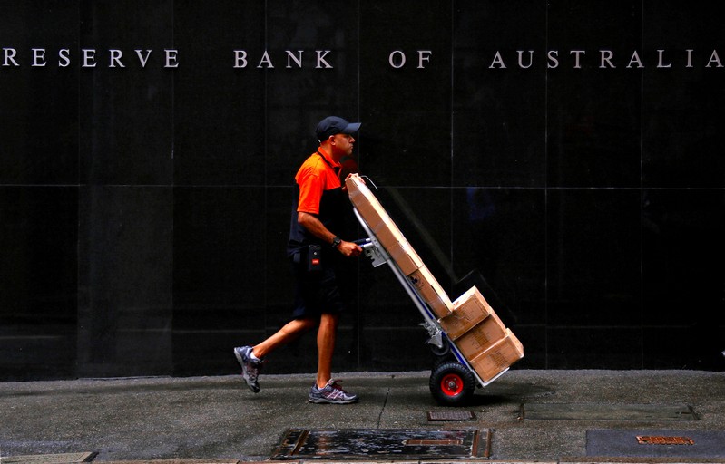 FILE PHOTO: A worker delivering parcels pushes a trolley past the Reserve Bank of Australia building in central Sydney, Australia