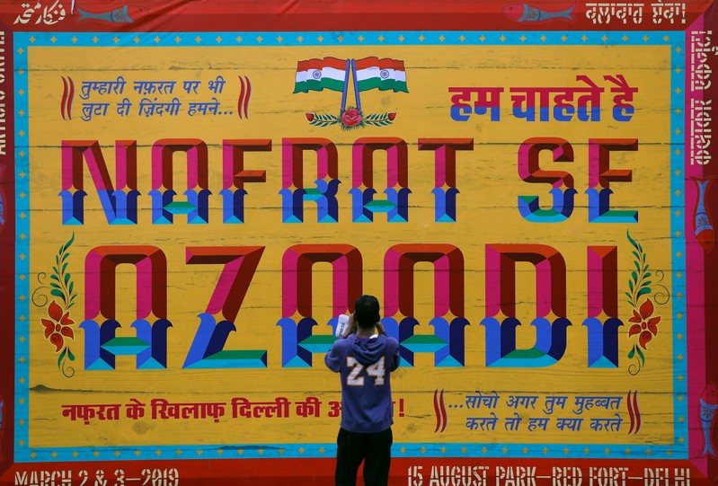 A man takes a picture of an art installation at an event titled