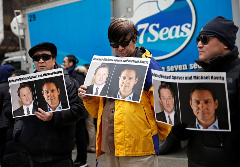 People hold placards calling for China to release Canadian detainees Michael Spavor and Michael Kovrig outside a court hearing for Huawei Technologies Chief Financial Officer Meng Wanzhou at the B.C. Supreme Court in Vancouver