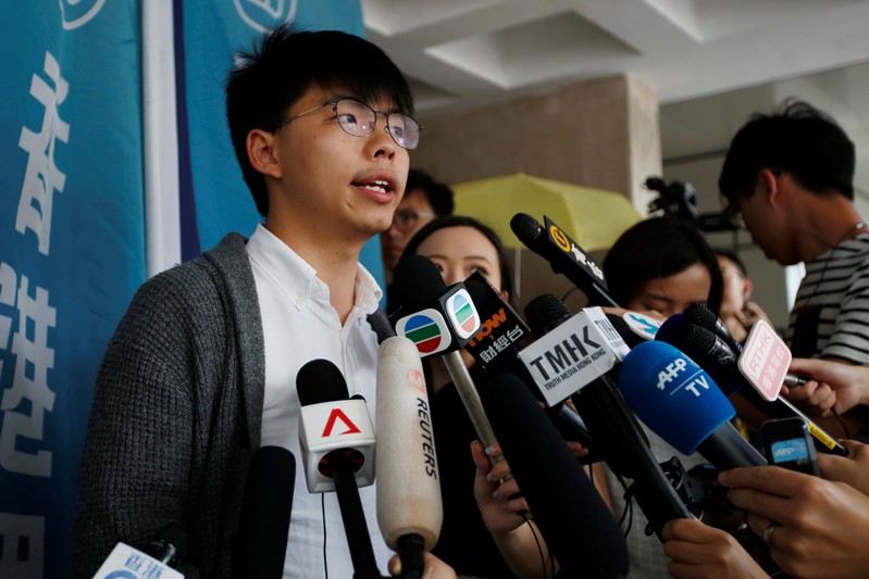 Hong Kong's pro-democracy activist Joshua Wong speaks to members of the media at the High Court in Hong Kong