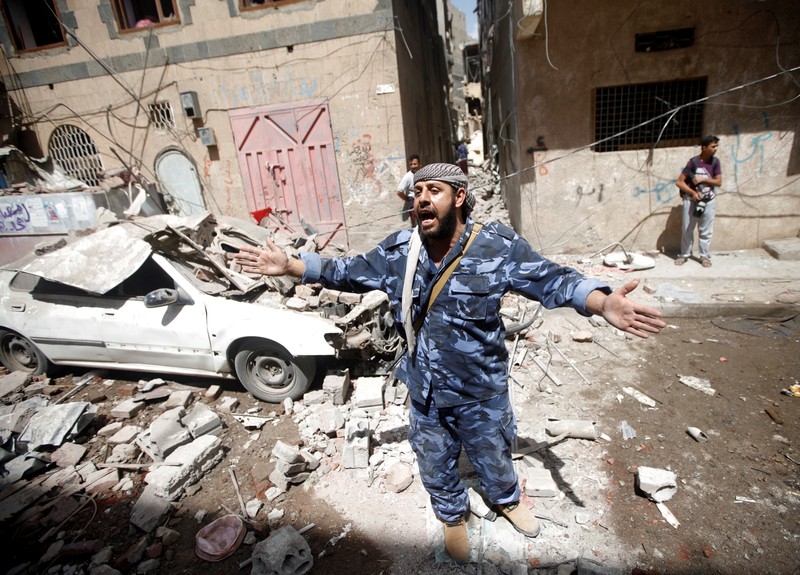 A Houthi security officer reacts at the site of an air strike launched by the Saudi-led coalition in Sanaa
