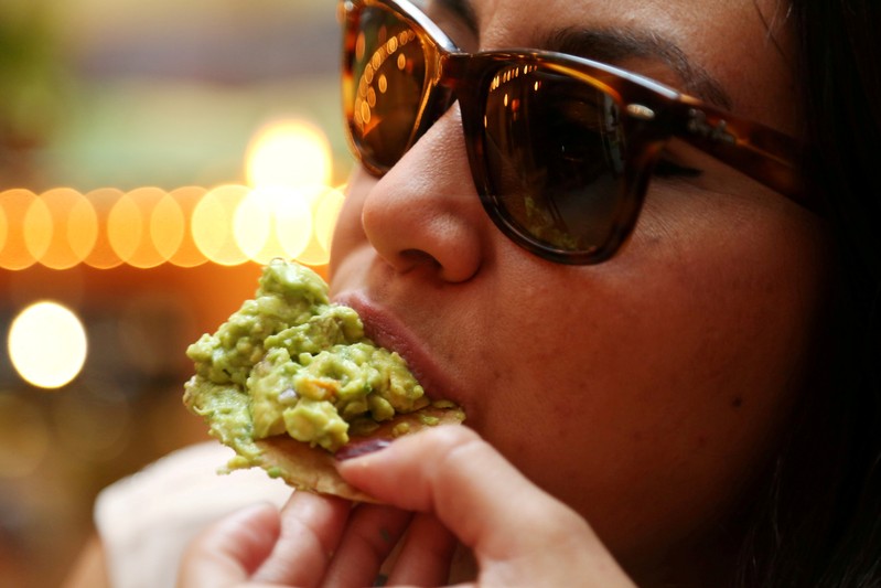 FILE PHOTO: A woman eats guacamole in this picture illustration, in Mexico City