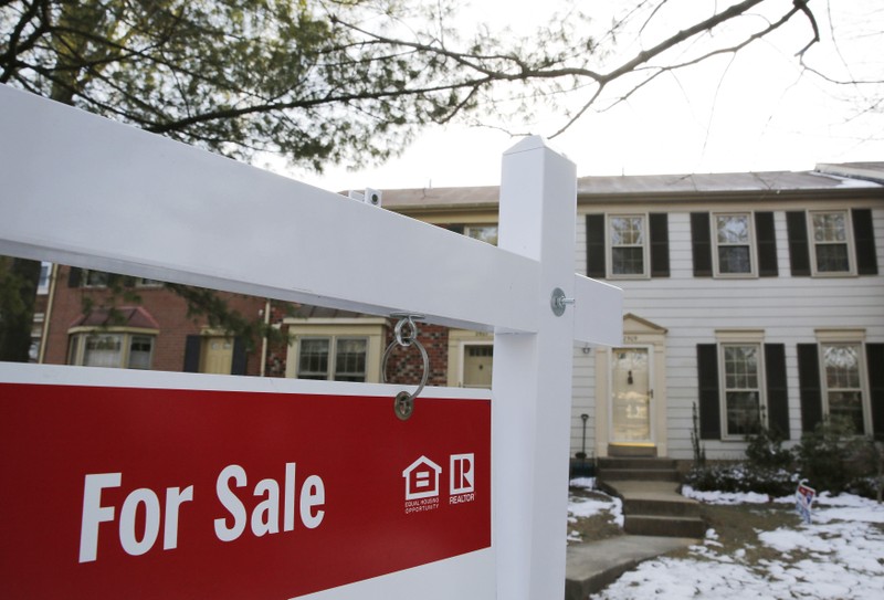 Home for sale sign hangs in front of a house in Virginia