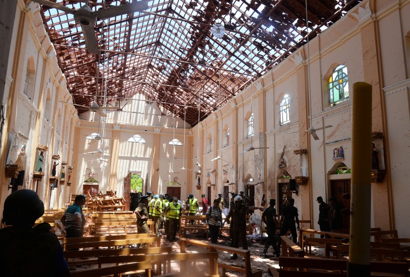 Crime scene officials inspect the site of a bomb blast inside a church in Negombo