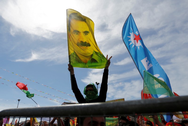 FILE PHOTO: A man holds a flag with a picture of imprisoned Kurdish rebel leader Ocalan during a gathering to celebrate Newroz, which marks the arrival of spring and the new year, in Istanbul