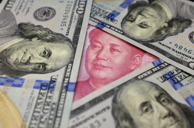 FILE PHOTO: U.S. 100 dollar banknotes and a Chinese 100 yuan banknote are seen in this picture illustration in Beijing, China
