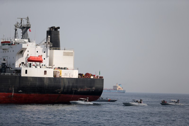 UAE Navy boats are seen next to Al Marzoqah, Saudi Arabian tanker, off the Port of Fujairah