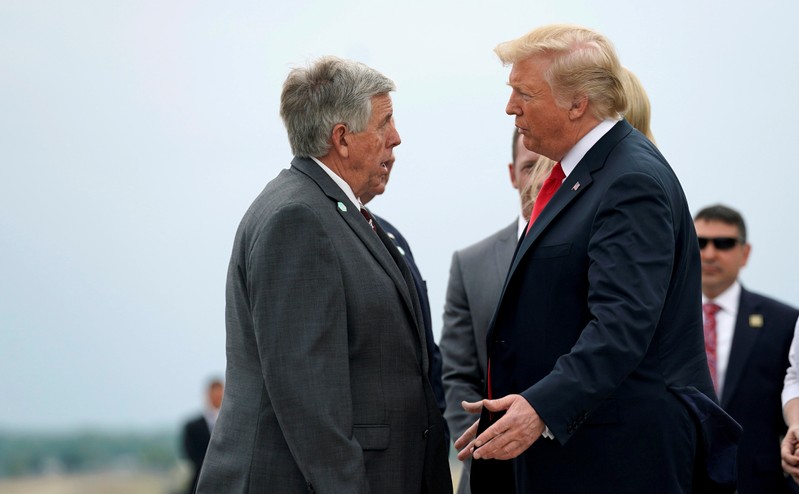 FILE PHOTO: U.S. President Trump speaks with the Governor of Missouri Parson as he arrives in St. Louis, Missouri