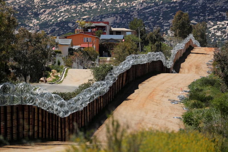 The border wall between the U.S. and Mexico is shown from the U.S. side near Tecate, California