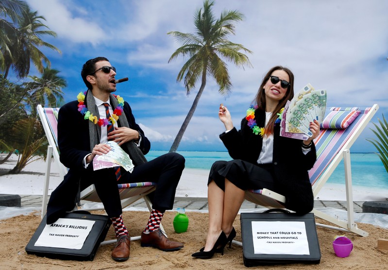 FILE PHOTO: Activists stage a protest on a mock tropical island beach representing a tax haven outside a meeting of European Union finance ministers in Brussels