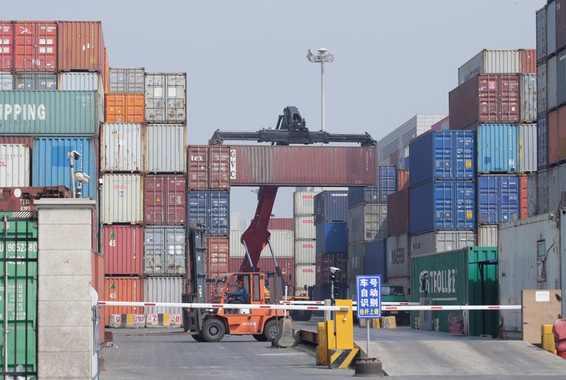 A container is carried onto a truck in a logistics center near Tianjin Port